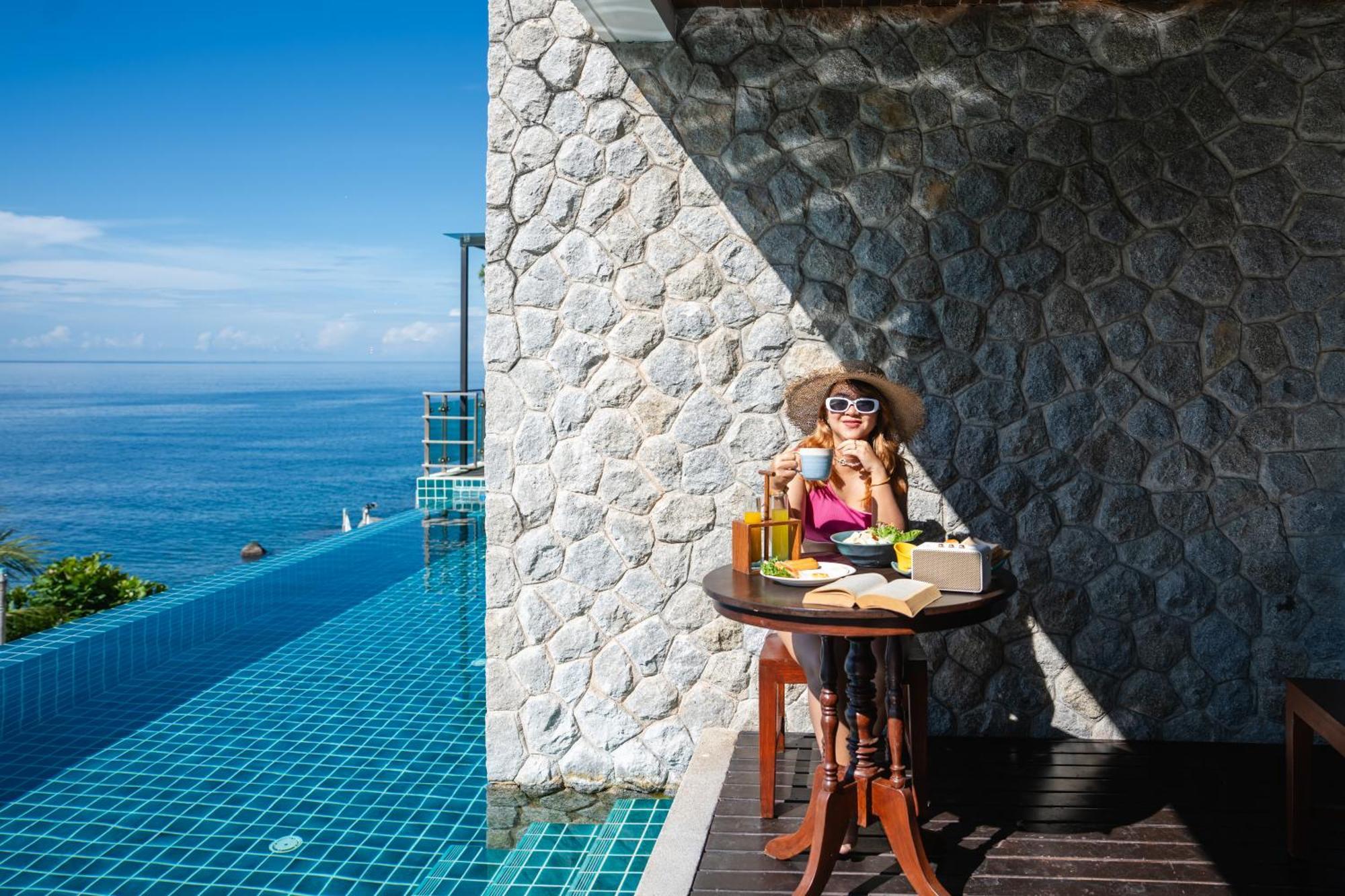 Zenmaya Oceanfront Phuket, Trademark Collection By Wyndham Patong Bagian luar foto A woman enjoying a morning coffee at the poolside of the resort